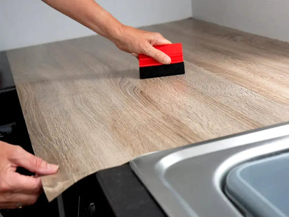 Squeegee for applying film, stickers and decals, made of plastic with one side covered in felt